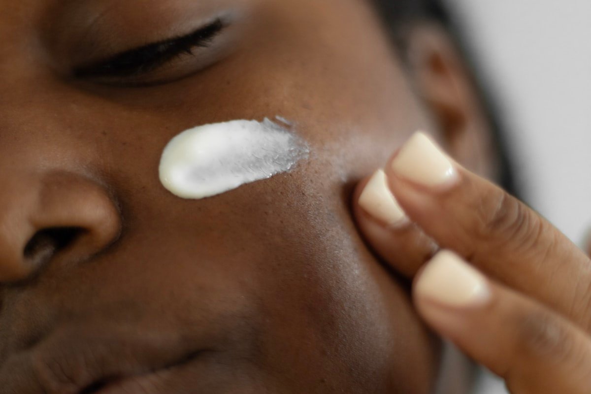Black woman applying a professional skincare cream