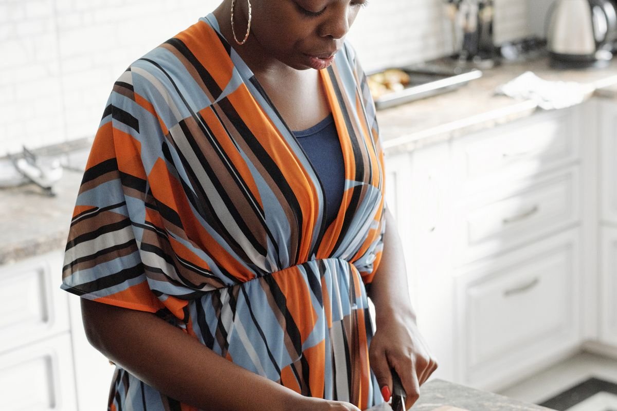 Black woman preparing a fresh healthy meal in a home kitchen