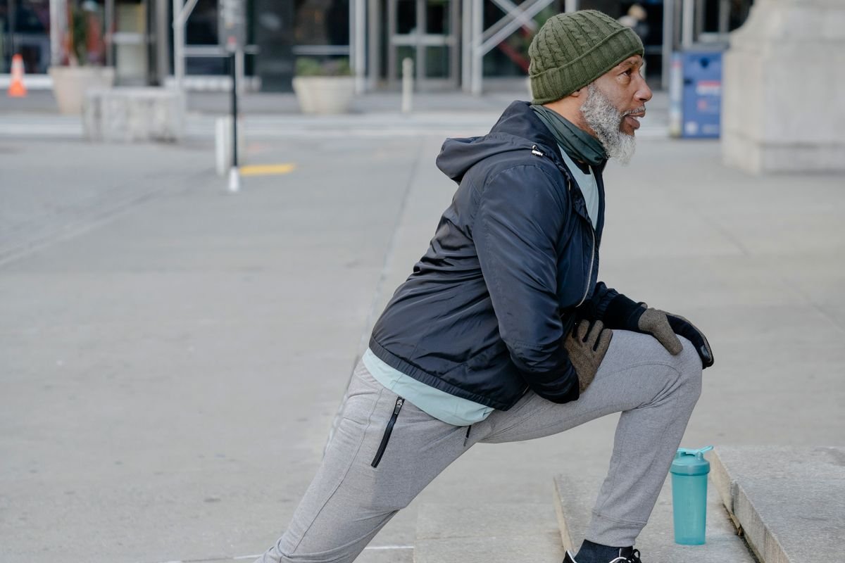 Older Black man stretching during an accessible wellness session